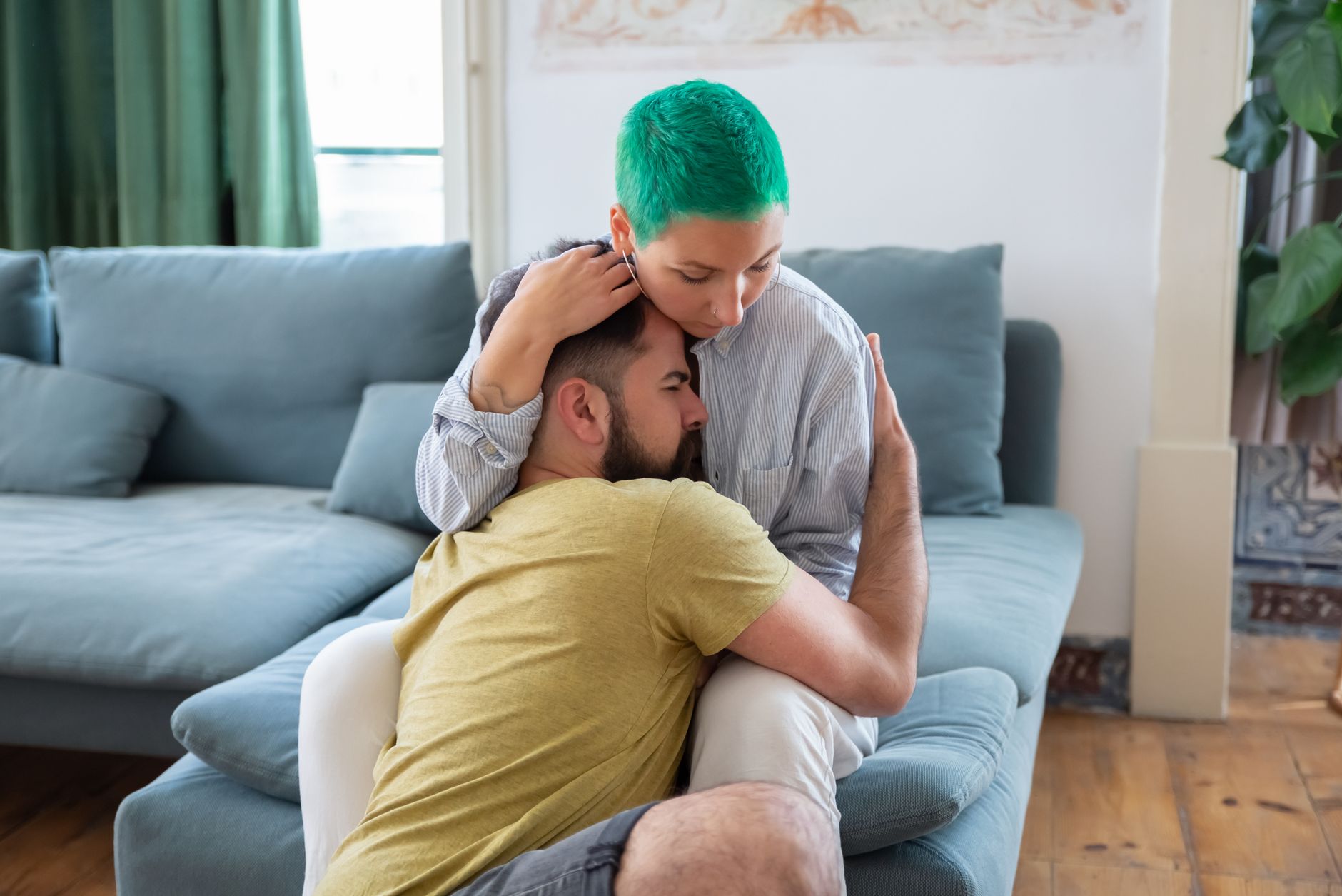 Een stel omhelst elkaar in de woonkamer
